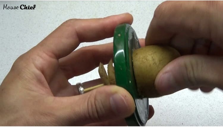 Прижмите картофелину к крышке и начинайте крутить её по часовой стрелке с нажимом